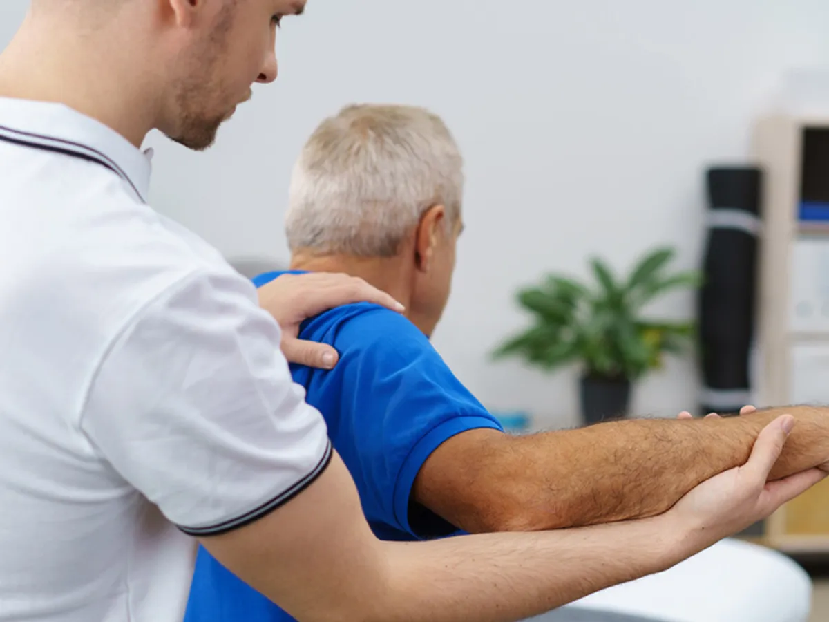 Physiotherapist helping an older client with exercises during a home visit on the Gold Coast